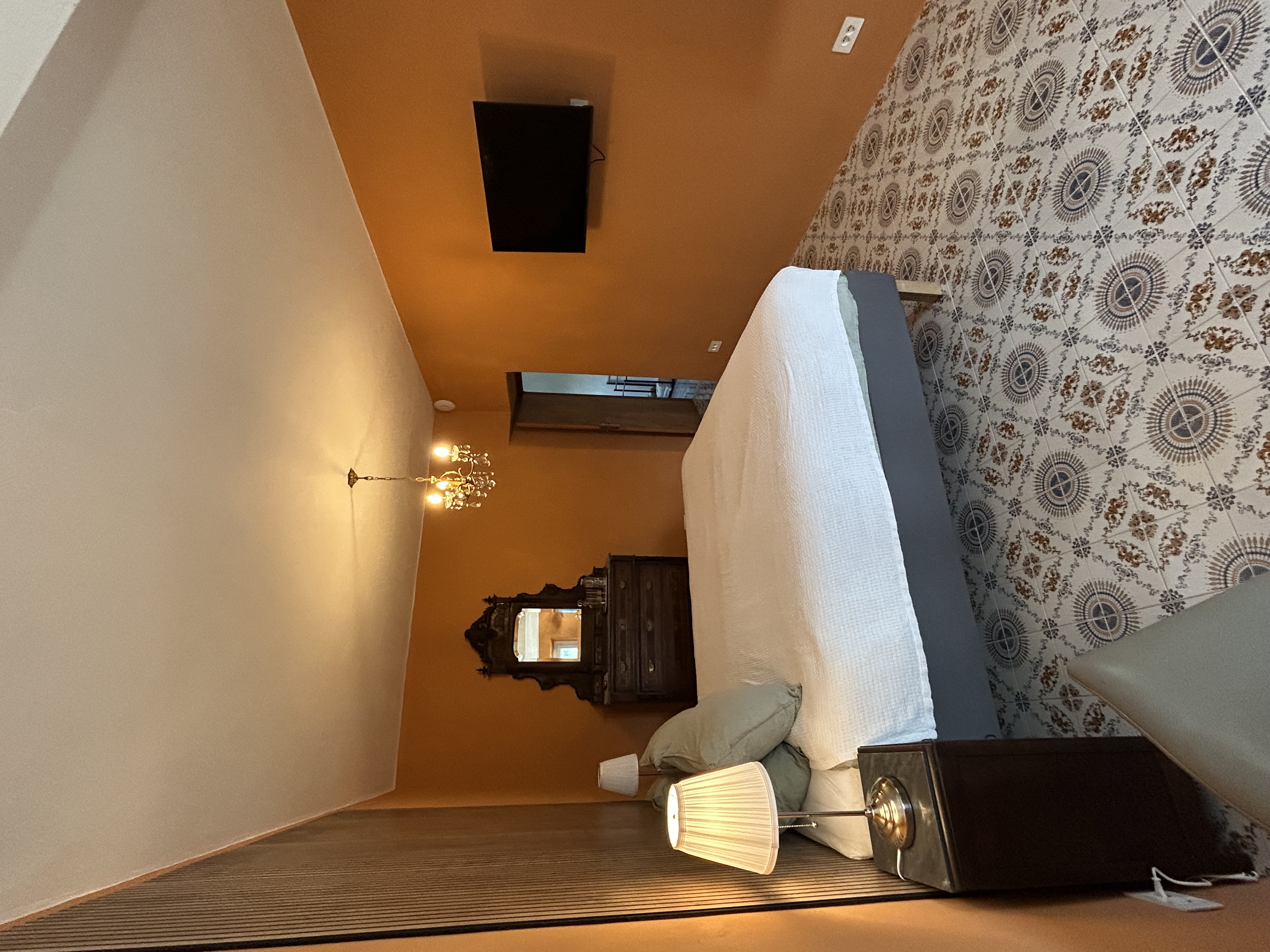 Appartement Toscana — slaapkamer met bed, TV en antieke spiegel